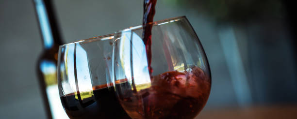 istock Pouring red wine on a wooden oak table 1160699978
