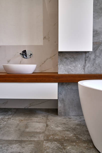 istock Stylish interior of modern bathroom with teak tabletop and marble walls 1160700242