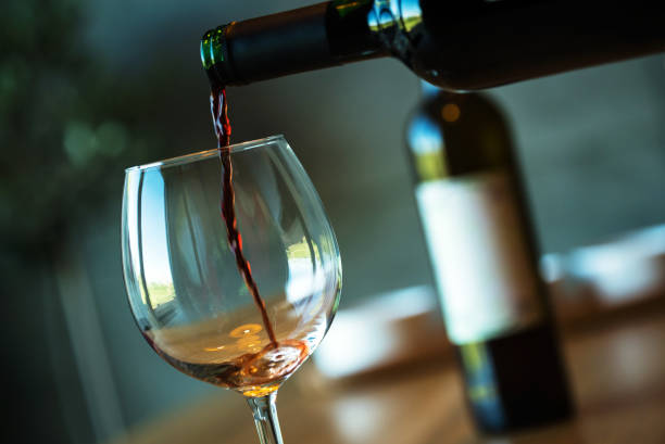 istock Pouring red wine on a wooden oak table 1160702120