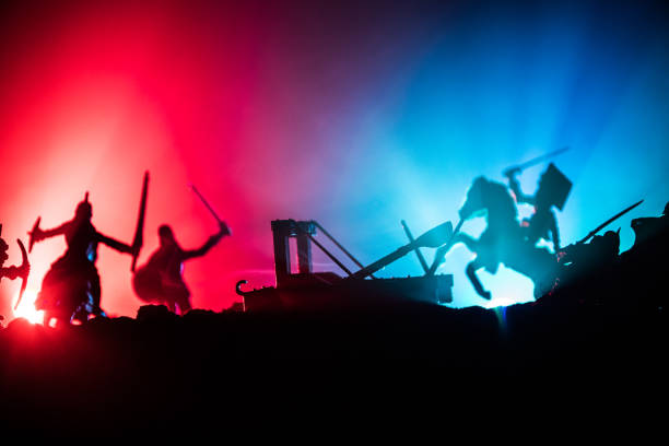 istock Medieval battle scene with cavalry and infantry. Silhouettes of figures as separate objects, fight between warriors on dark toned foggy background with medieval castle. 1160707530