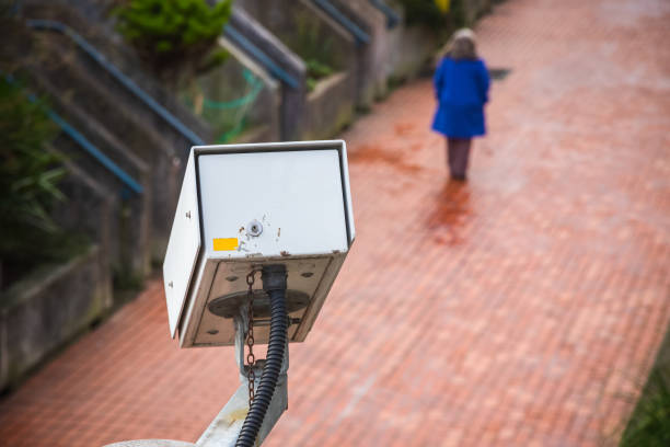 istock Surveillance camera with an unidentified walking person in the background 1160711324