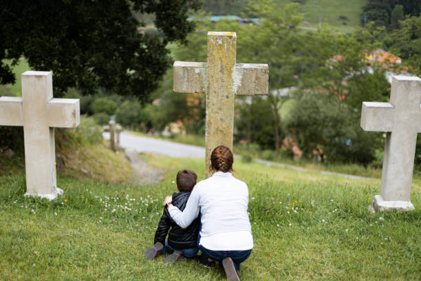 matka i syn przed krzyżem - cemetery child mourner death zdjęcia i obrazy z banku zdjęć