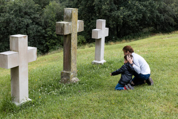 어머니 과 아들 에 앞 의 a 십자가 - cemetery child mourner death 뉴스 사진 이미지