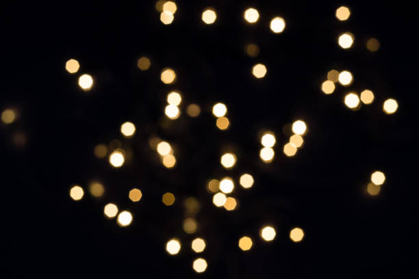 Flying golden bokeh lights in hexagon shape on black. Holiday concept Flying golden bokeh lights in hexagon shape on black. Holiday concept. flicker bird stock pictures, royalty-free photos & images