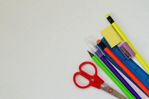 High quality stock photos of multi-colored desk caddy with pencils, erasers and assorted school supplies on a white background.