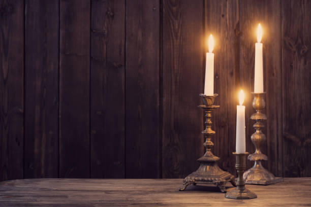 istock burning candle on old wooden background 1160723744
