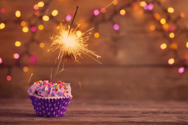 istock cupcake with sparkler on old wooden background 1160723780