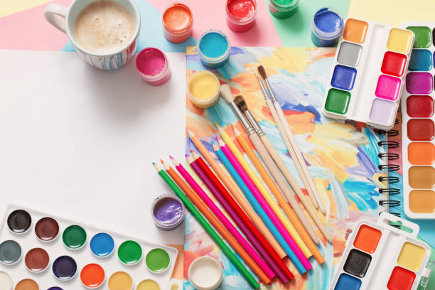 istock cup of coffee and paints, pencils on white background 1160723787