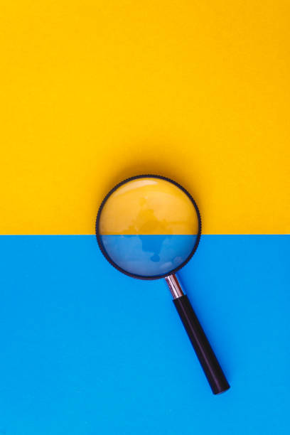 istock Magnifier lies on yellow and blue background. View from above. Flat lay. Copy space 1160725212