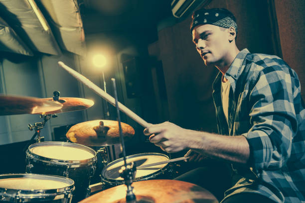 istock selective focus of handsome drummer holding drum sticks while playing drums 1160726994