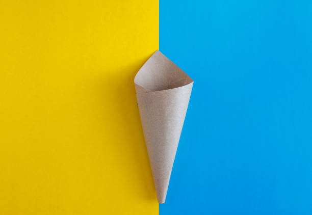 paper craft blank cone on blue and yellow background. top view. Flat lay, save space