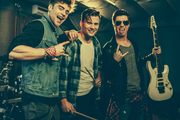 istock handsome and cheerful rock band smiling while showing rock signs 1160727191