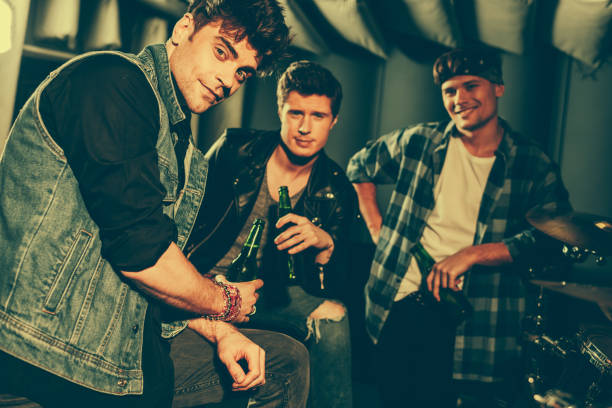 istock selective focus of handsome men holding bottles with beer while looking at camera 1160727367