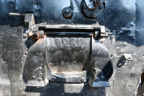 Detail shot of steam boiler of steam locomotive built in 1920. cover and gear arm.