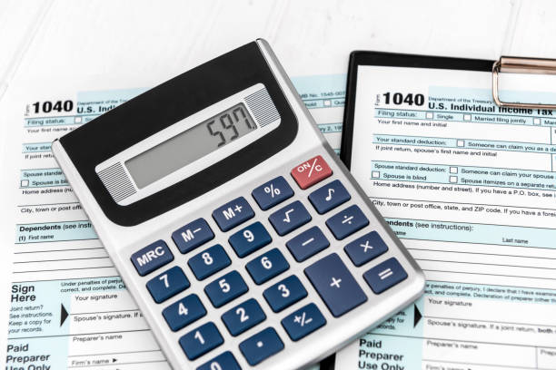 istock Calculator on tax forms on white wooden background 1160728896