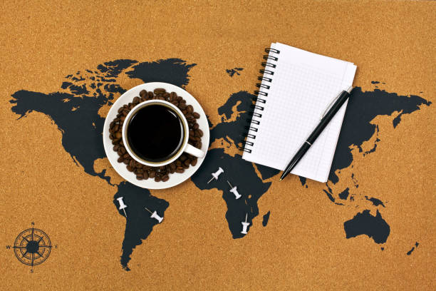 istock Cup of black hot coffee with coffee beans on a map with pen and notepad 1160729515