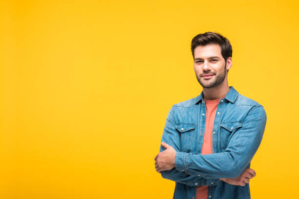 istock happy handsome man with crossed arms looking at camera Isolated On yellow 1160729806