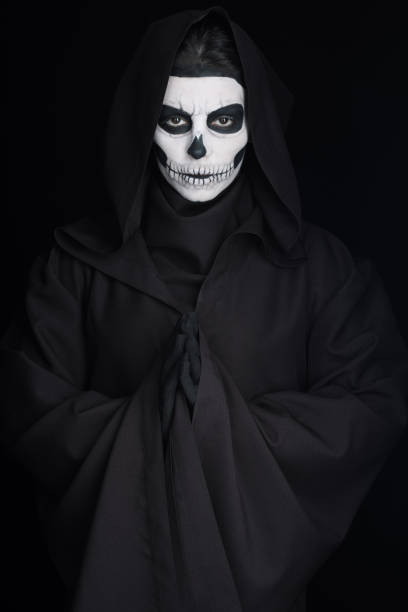 istock woman with skull makeup showing please gesture isolated on black 1160730782