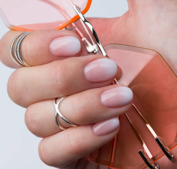istock Beautiful manicured hand with rings holding sunglasses. 1160733573