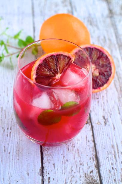 istock Blood orange cocktail drink with ice cubes and mint leaf 1160733590