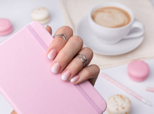 istock Beautiful manicured hand holding notepad at the office table. 1160733608