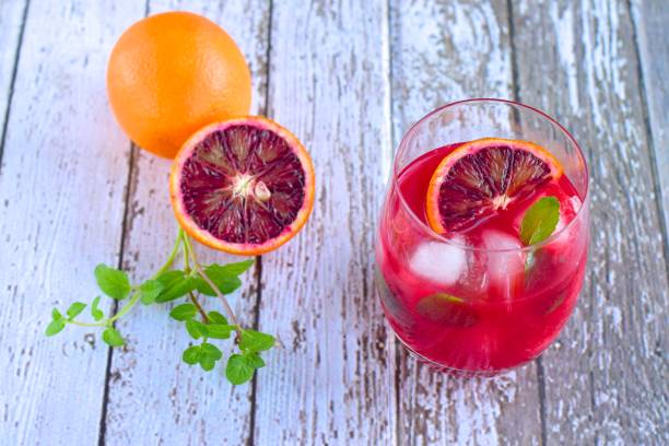 istock Blood orange cocktail drink with ice cubes and mint leaf 1160733623