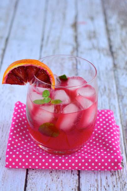 istock Blood orange cocktail drink with ice cubes and mint leaf 1160733656