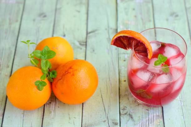 istock Blood orange cocktail drink with ice cubes and mint leaf 1160733671
