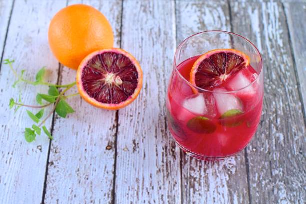 istock Blood orange cocktail drink with ice cubes and mint leaf 1160733750
