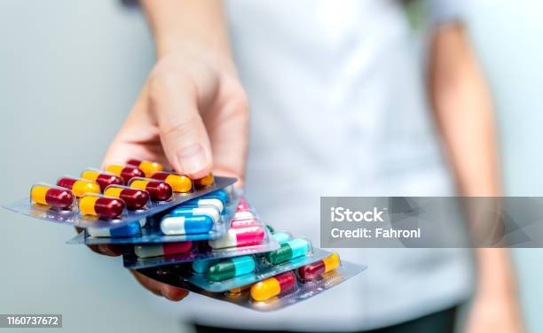 Pharmacist Or Doctor Hand Holding Pack Of Antibiotic Capsule Pills And Giving Patient Or People Antibiotic Drug Overuse Antimicrobial Drug Resistance Community Pharmacist Drugstore Background Stock Photo - Download Image Now