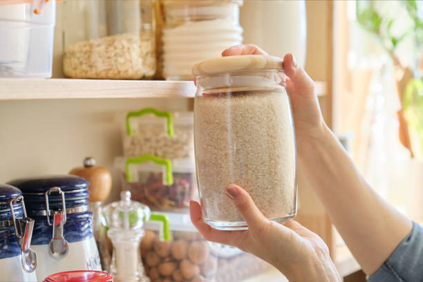Food products in the kitchen. Woman taking jar of rice Food products in the kitchen storing ingredients in pantry. Woman taking jar of rice rice food staple stock pictures, royalty-free photos & images