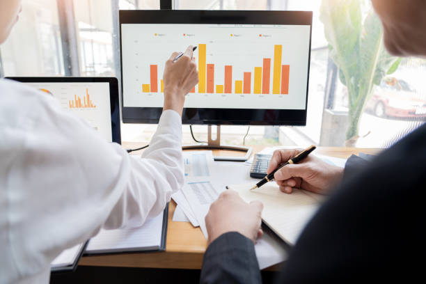 istock Midsection Of Coworkers Discussing Over Computer In Office 1160741654