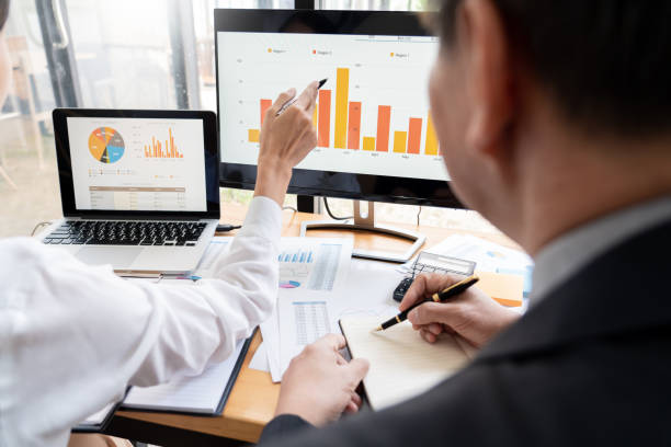 istock Midsection Of Businesswoman Using Computer With Colleague At Office 1160742086
