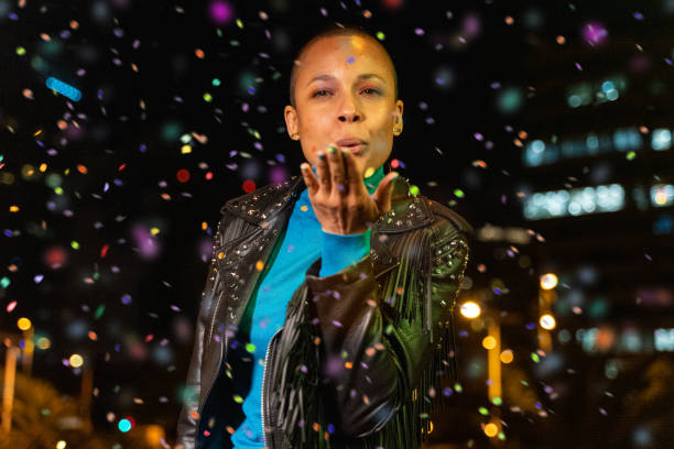 istock Woman blowing confetti outdoors 1160743222