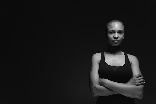 Black and white portrait of a woman with shaved hair.