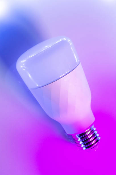 istock Smart Home RGB bulb lamp in trendy backlight. LED Bulb, multicolor backdrop inspired by neon trend. Top view, copy space for your design 1160744787