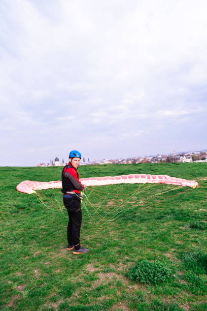 istock Man landed and folds parachute lying on ground 1160745442