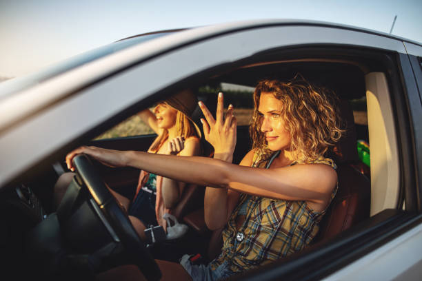 istock Beautiful girls singing while driving a car 1160745563