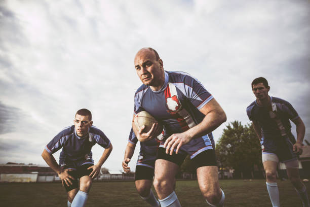 istock Rugby players running with ball on a playing field. 1160746110