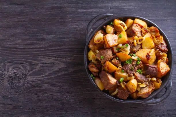 Tasty food: succulent beef with fried potatoes, onion and garlic. Country-style roasted potatoes with meat