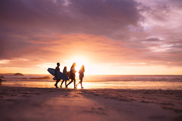 istock Silhouette of people walking on beach at sunset 1160747020