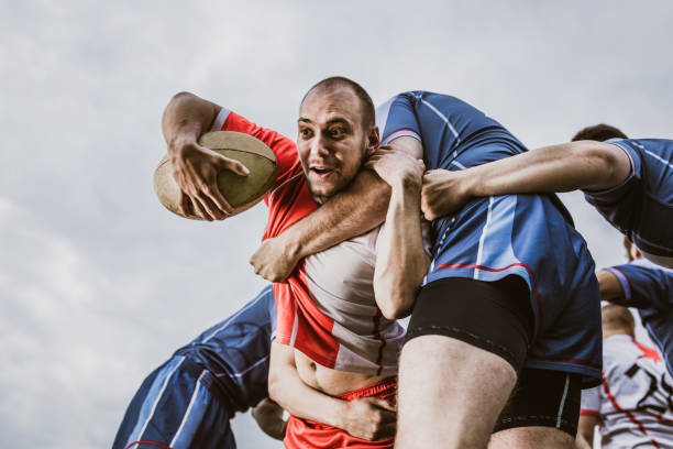 istock Aggressive rugby player making an effort while trying to pass his rivals on a match. 1160747856