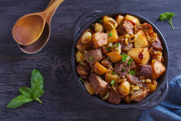 istock Tasty food: succulent beef with fried potatoes, onion and garlic. Country-style roasted potatoes with meat 1160748607
