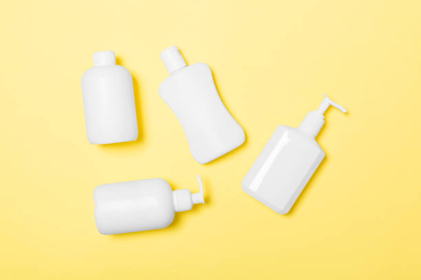 istock Set of White Cosmetic containers isolated on yellow background, top view with copy space. Group of plastic bodycare bottle containers with empty space for you design 1160749877