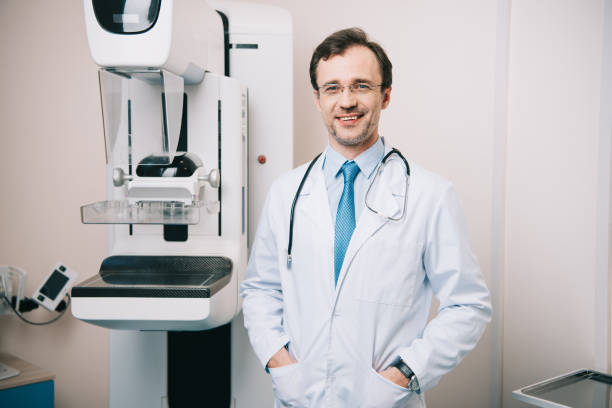istock handsome radiologist standing near x-ray machine and looking at camera 1160758724