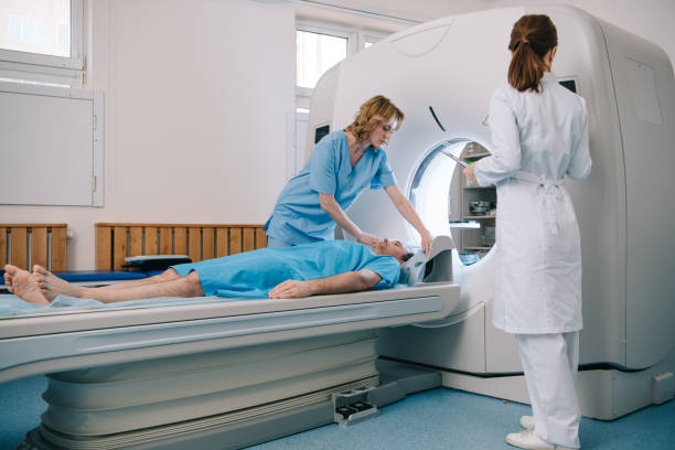 istock radiologist in white coat standing near ct scanner while nurse preparing patient for diagnostics 1160758729