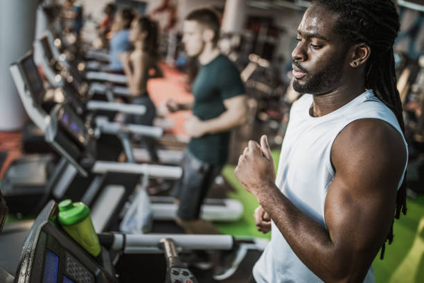 istock Young black athlete running on treadmill in a gym. 1160759978