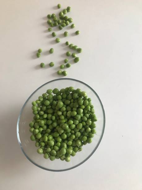 istock Green peas in bowl on white background, top view 1160760487