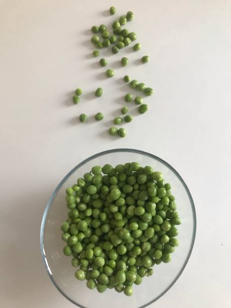 istock Green peas in bowl on white background, top view 1160760501