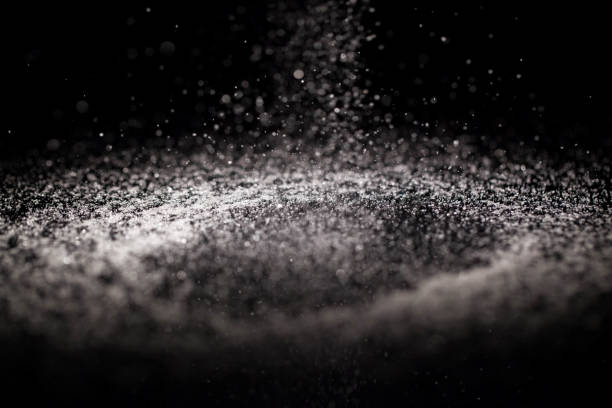 istock Crystals of sugar fall on black glass table 1160762642
